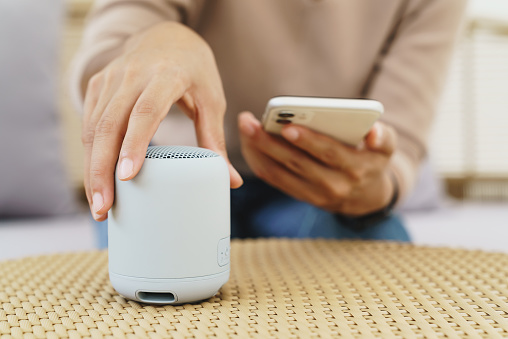 primer plano en la mano usando el teléfono que conecta el altavoz bluetooth photo