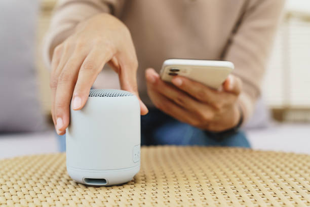 close-up on hand using phone connecting speaker bluetooth stock photo