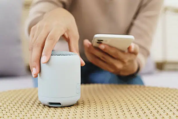 Photo of close-up on hand using phone connecting speaker bluetooth