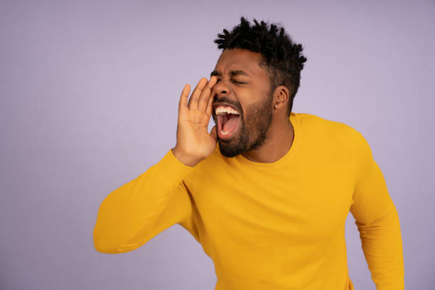 istock Afro man yelling at someone while standing on an isolated background. 1345324651