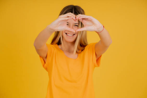 istock Young woman smiling while making a heart with her hands. 1345324711