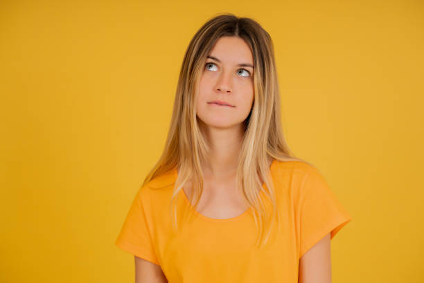 istock Young bored woman standing on an isolated background. 1345324714