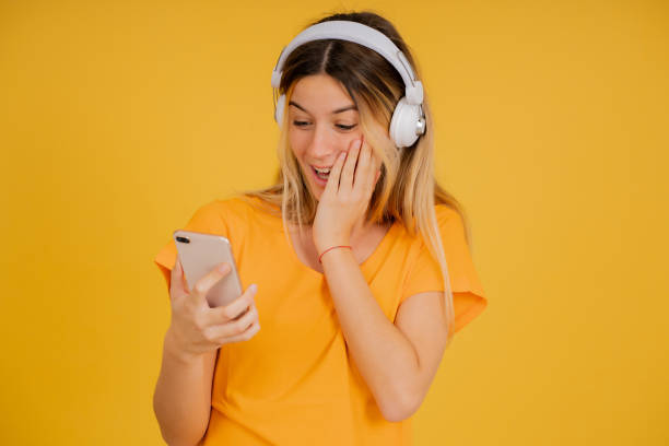 istock YYoung woman looking surprised at her mobile phone. 1345324726
