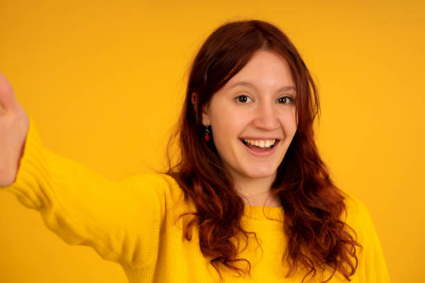 istock Young woman looking at camera and taking a selfie. 1345325138