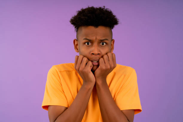 istock Scared man looking at camera while putting a hand on his mouth. 1345326246