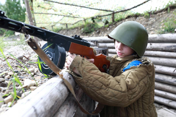 istock Boy with PPSh-41 submachine gun in trench 1345328670