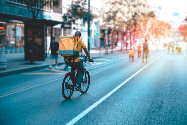 Courier on bicycle with parcel, bike delivery service Bike Courier On City Street with delivery box on back riding stock pictures, royalty-free photos & images