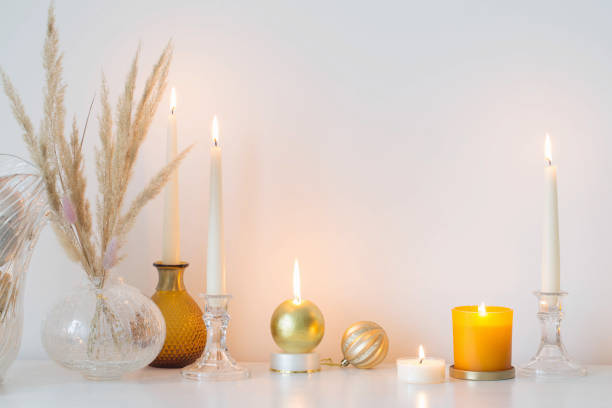 istock christmas decorations with burning candles in white room 1345336697