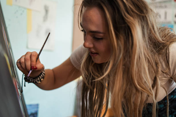 istock In creative mode, teenage artist painting on the canvas 1345339708