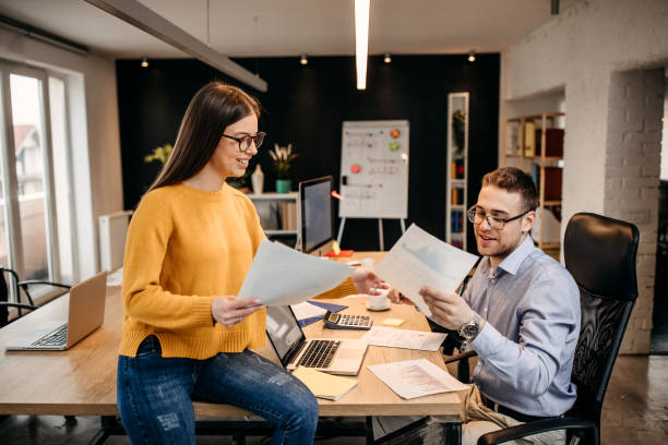 istock Business people working together in bright office, sitting at desk 1345340876