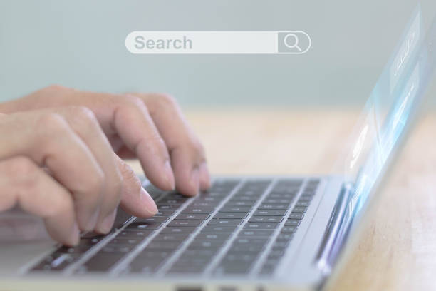 istock Man's hand using laptop for searching data on internet, with search box icon and copyspace. 1345342387
