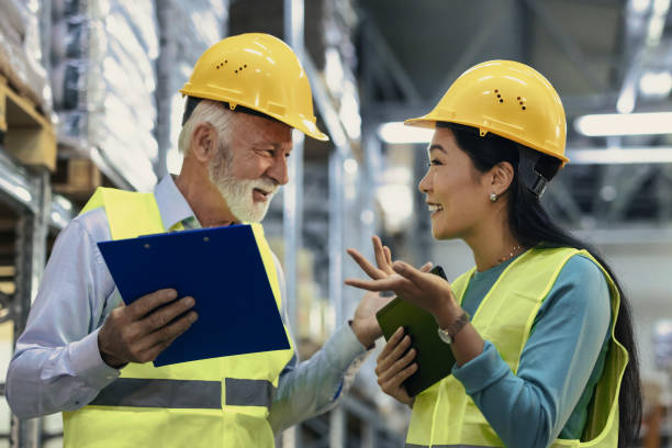 Scheduling the next shipment Warehouse female worker and senior manager working on project together in a distribution warehouse age contrast stock pictures, royalty-free photos & images