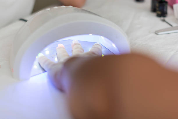 istock Female hand in the lamp for manicure 1345344774