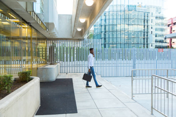 istock young black business man talking on the phone with briefcase leaving office 1345345892