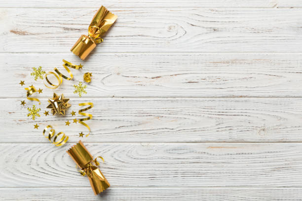 istock Christmas crackers with shiny confetti on color background, top view, copy space 1345346069