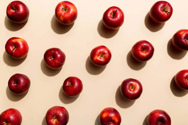 istock Many red apples on colored background, top view. Autumn pattern with fresh apple above view 1345346099