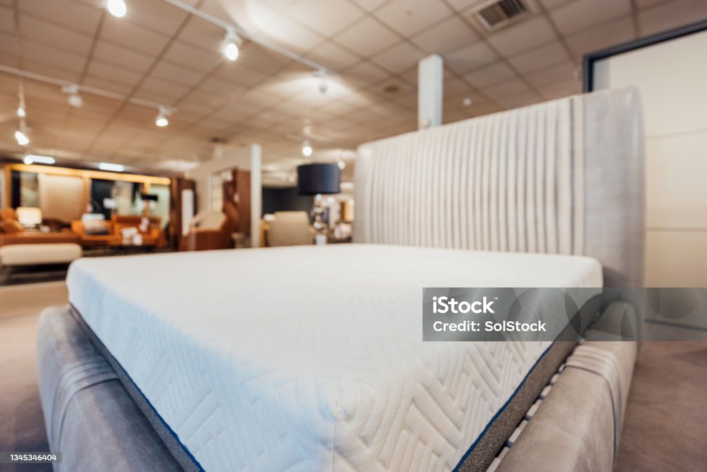 Showroom Bed and Mattress A Soft new mattress in showroom on sale for customers. Mattress Stock Photo