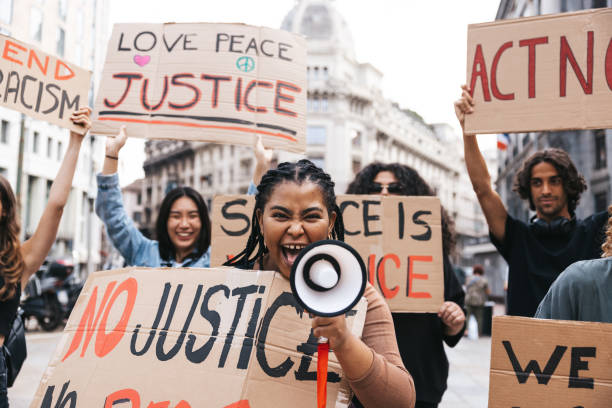 istock Young woman shouting on megaphone during a protest 1345350124