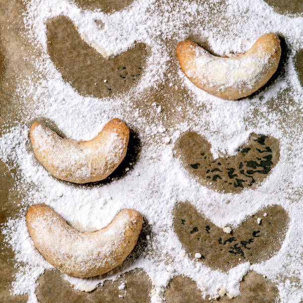 Homemade traditional Christmas shortcrust cookies vanilla crescents with icing sugar on baking paper. Top view. Square image