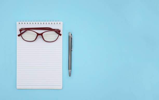 istock Blank notepad with red glasses and a pencil on the side 1345352965