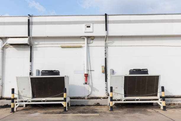 istock Air conditioner compressor installed in old building. Cooling towers in data center building.  Industrial cooling towers or air cooled water chillers with piping system. 1345355522