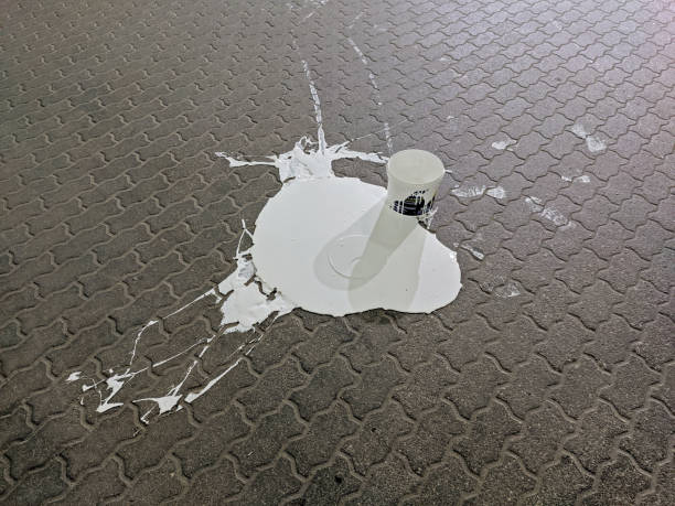 istock Bucket of white paint spilled on paving slabs 1345357355