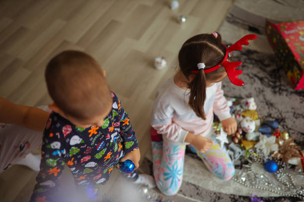 istock Playful siblings together decorating Christmas tree 1345357490
