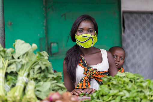 Portrait woman wearing mask working at vegetable market stall