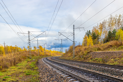 Golden autumn landscape on empty curved railroad in Siberia. Industrial landscape.