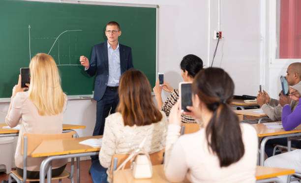 istock Teacher explaining new theme to adult students 1345359732