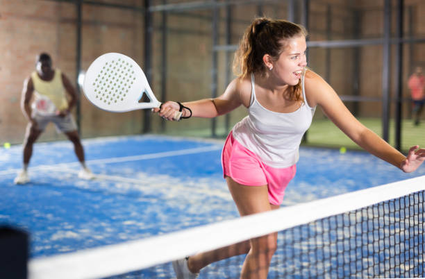 jeune sportive expressive jouant au paddle-tennis sur un court intérieur - forehand photos et images de collection