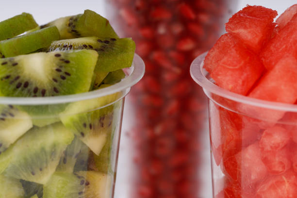 Watermelon , pomogrenate and Kiwi Slices arranged  in two transparent glasses with white background, isolated