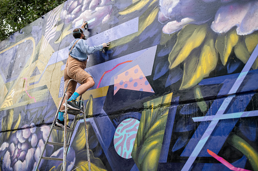 Melbourne, Australia - Sep 9, 2015: Street artist creating graffiti at Hosier Lane in Melbourne, Australia. Hosier Lane is a laneway in CBD of Melbourne, It is a popular landmark in Melbourne due to its graffitti covered walls and urban art.