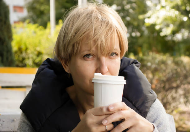 通りの肖像画のカフェでコーヒーを飲むペンシブな女性 - senior adult loneliness one person sadness ストックフォトと画像