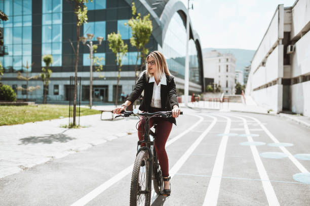 istock Beautiful Blond Businesswoman Riding Bicycle After Work 1345370228