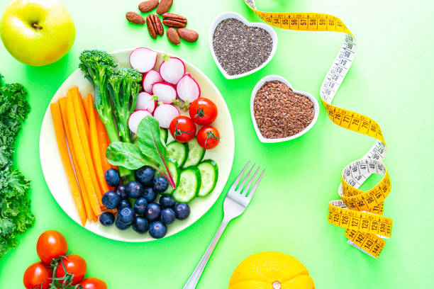 istock Healthy fresh vegetables plate on green background 1345371354