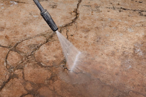 istock Worker cleaning dirty floor with high pressure washer 1345372659