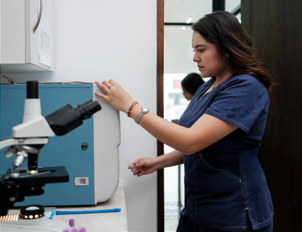 istock Lab worker looking at machine at vet clinic 1345375955