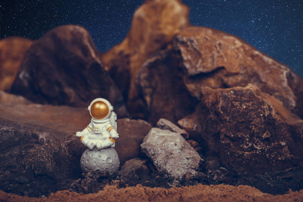 istock Astronaut wearing white space suit and helmet and meditating while sitting on the moon. 1345376047