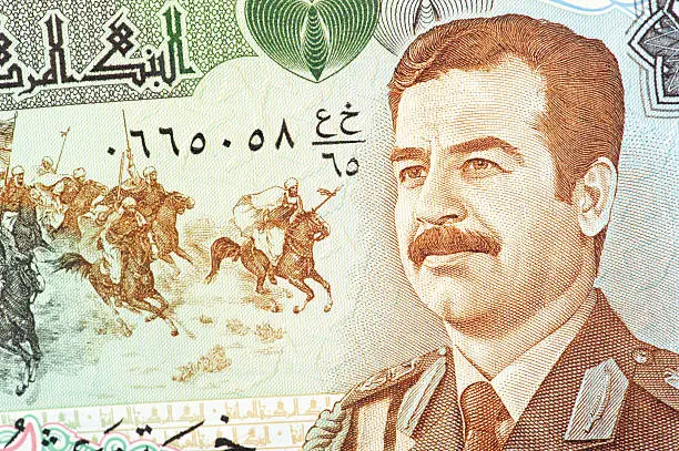 the former iraqi president saddam ussain, wearing military uniform, on a iraqi banknote.