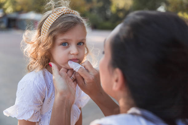 istock Little messy girl getting cleaned by her mother 1345380106