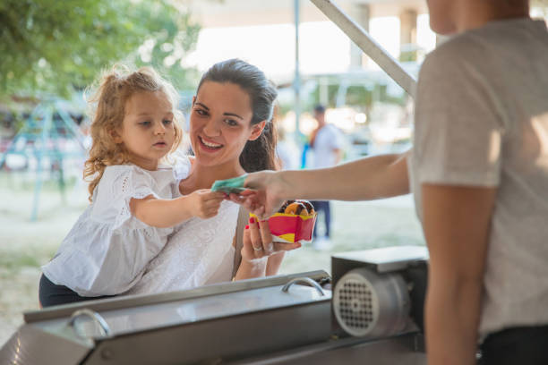istock Woman letting her toddler pay for donuts 1345380243