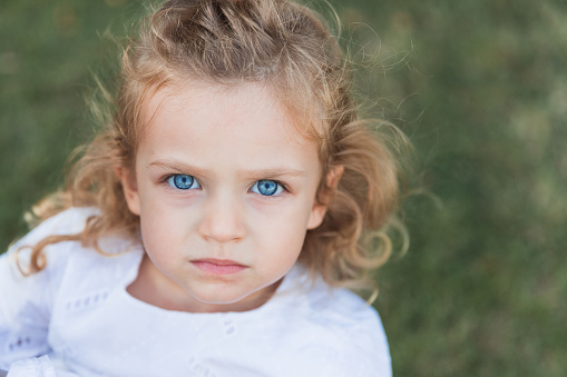 Displeased young girl with big blue eyes