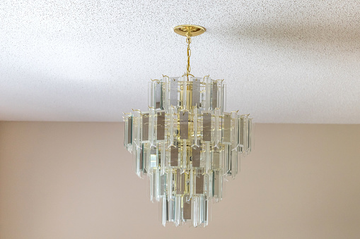 An old-fashioned retro hanging glass chandelier in a dining room.