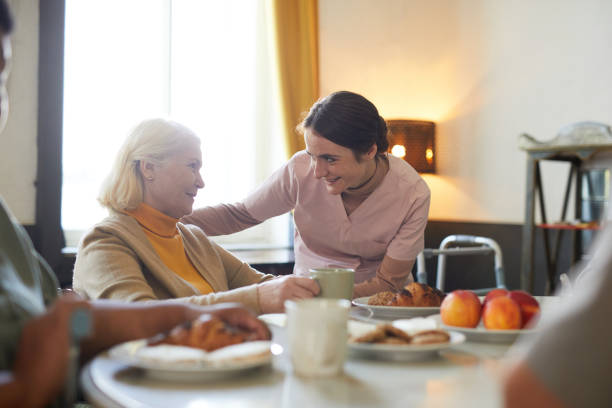 은퇴 가정에서 일하는 젊은 여성 - senior adult nursing home eating home interior 뉴스 사진 이미지