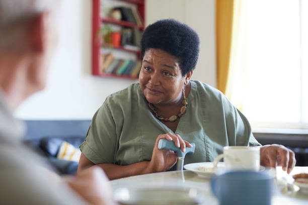 donna afroamericana in una casa di riposo - 60s senior adult breakfast cheerful foto e immagini stock
