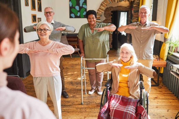 senioren trainieren im seniorenheim - men chair wheelchair sport stock-fotos und bilder