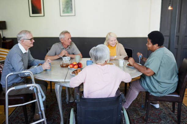 老人ホーム高齢者グループ - senior adult nursing home eating home interior ストックフォトと画像