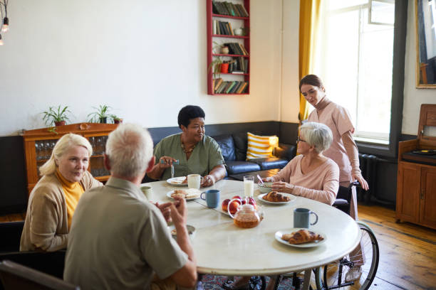 老人ホームの高齢者の多様なグループ - senior adult nursing home eating home interior ストックフォトと画像