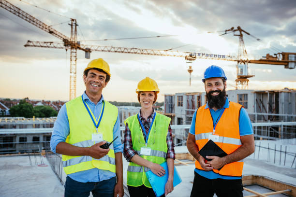istock Portrait of smiling construction engineers with protective helmets and reflective wests 1345385363